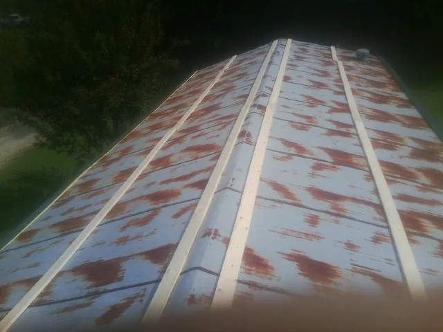 Rusted metal roof panels with new wood purlins before replacement — Storm Damage Roof Repair in Sagamore Beach by Roofing Brothers