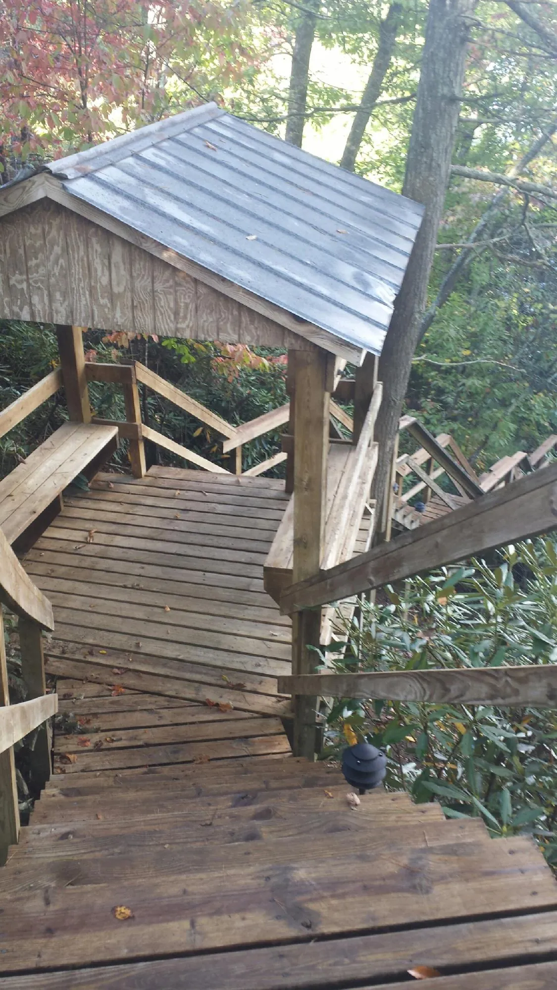 Metal roofed shelter over wooden steps on a wooded walkway — Skylight Repair & Installation work by our crew in Sagamore Beach