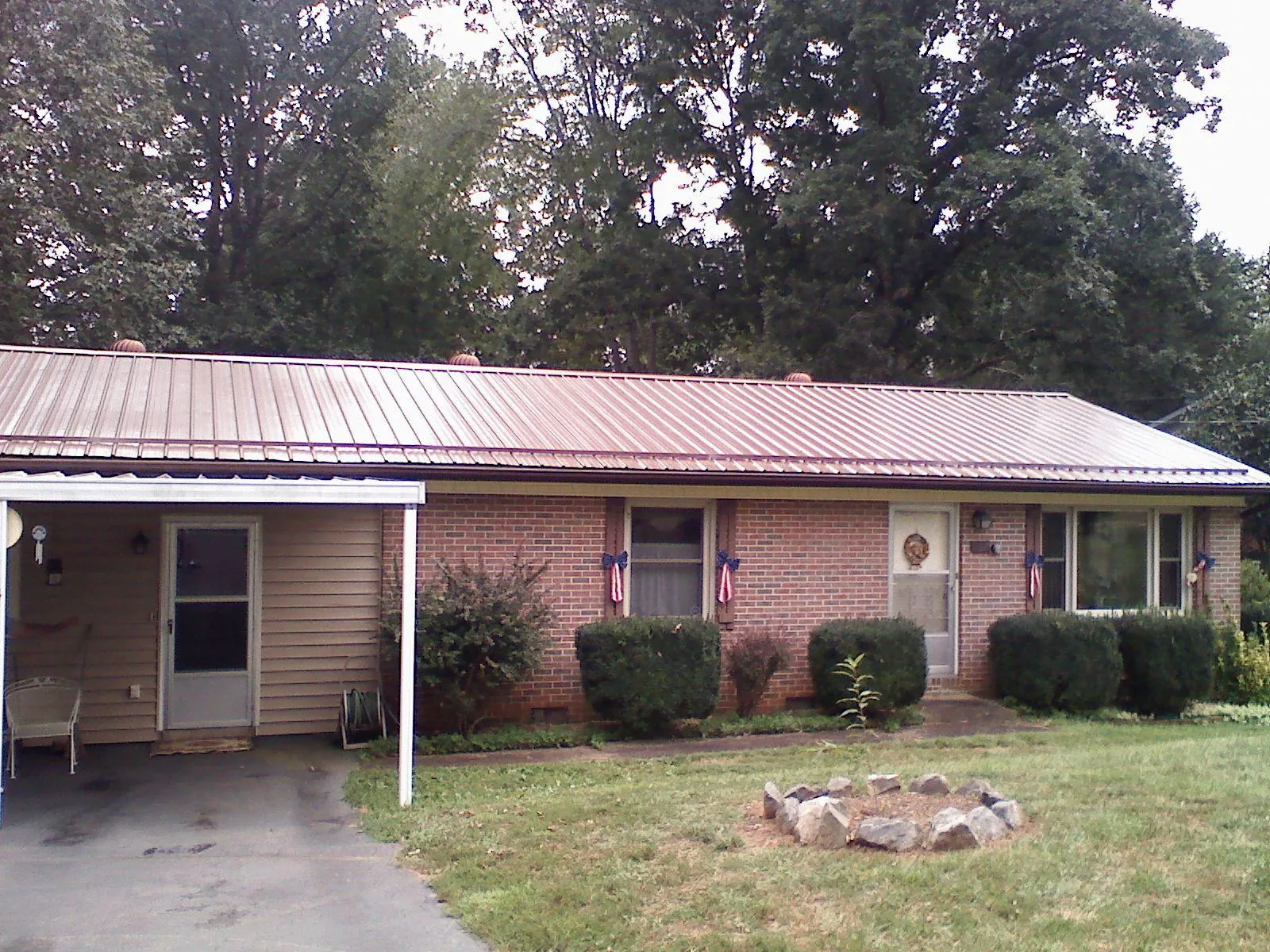 Bronze metal roof and carport on a brick ranch home — Roof Repair work by our crew in Sagamore Beach
